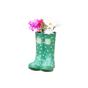 Green polka dot rain boot with flowers on a wooden surface